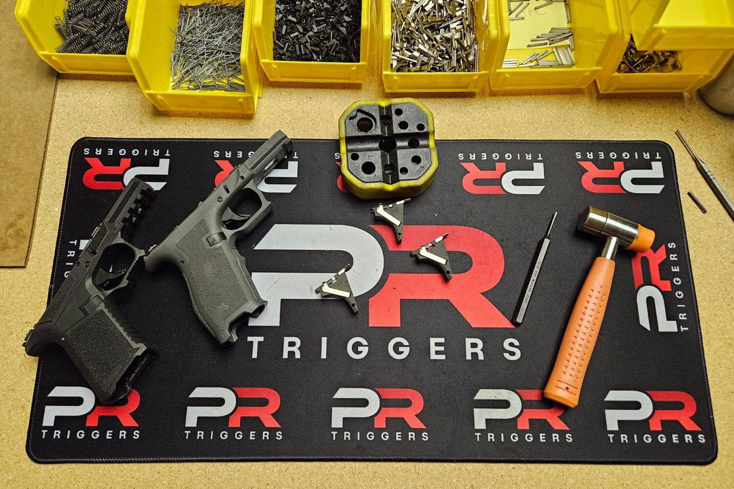 two pistol frames and components of a PR Triggers Model G pull release trigger